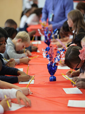 A row of National Heritage Academies students writing thank-you notes as part of Project Gratitude. A row of National Heritage Academies students writing thank-you notes as part of Project Gratitude.