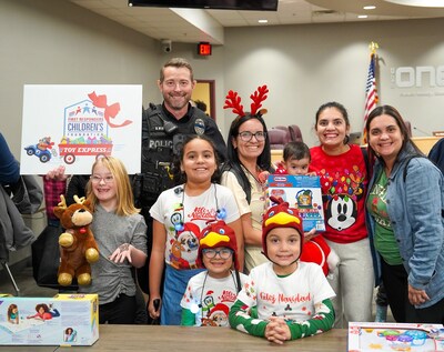 A police officer distributing toys to children in his community at a Toy Express event.