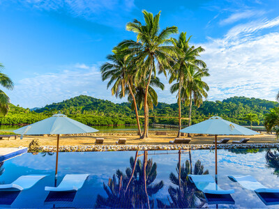 Wavi’s existing, resort-style amenities include a 3-bed, 1-bath manager’s home, large pavilion with bar and lounge, “lagoon-style” marina and community pool, pictured here. Also visible is the island’s private access bridge (center/right; background), connecting Wavi to the Vanua Levu mainland. FijiLuxuryAuction.com.