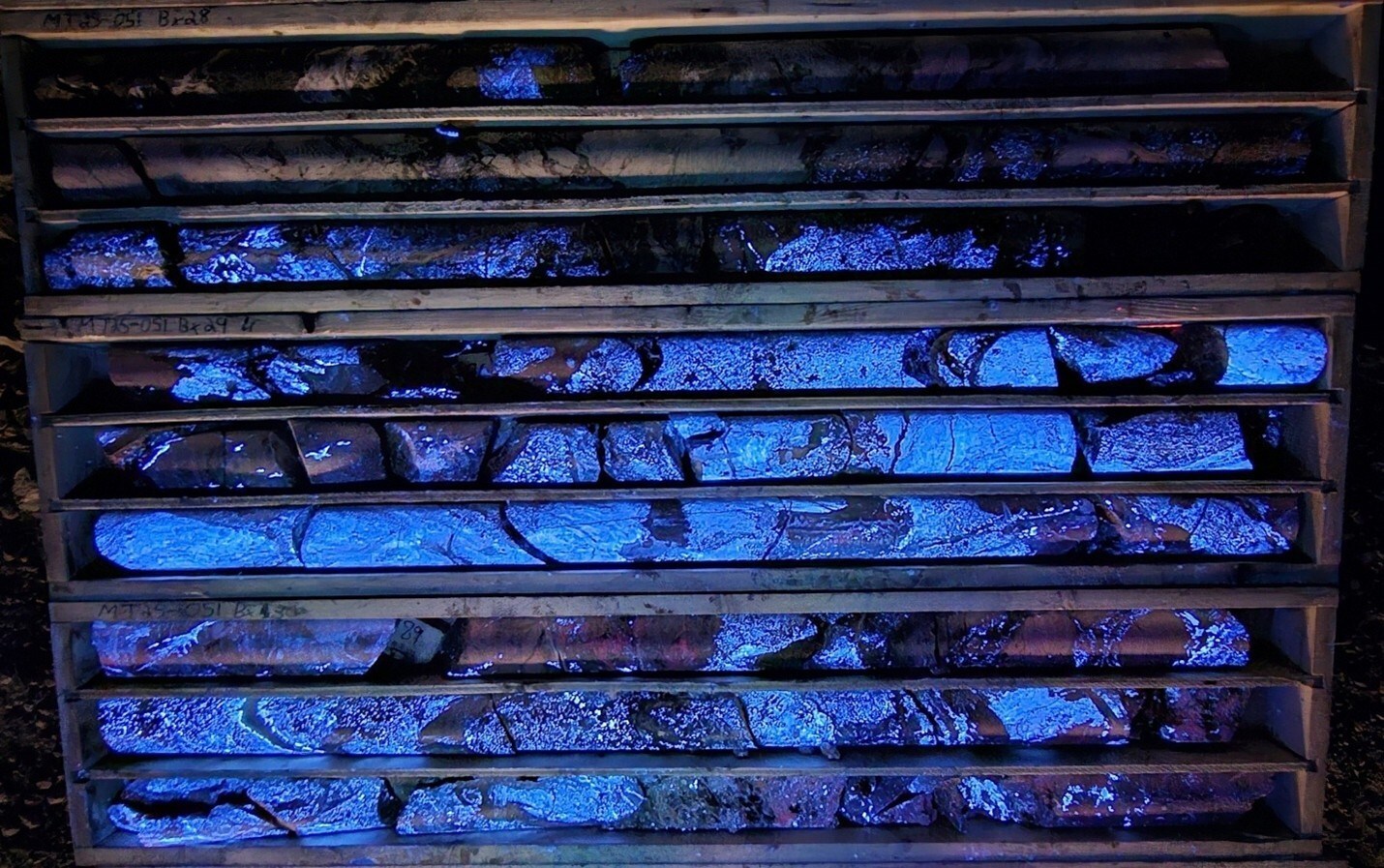 Photo 1: 82.47 m to 91.80 m in MT25-051 displaying high-grade scheelite (CaWO4) mineralization fluorescing under short wave UV. (CNW Group/Fireweed Metals Corp.) Photo 1: 82.47 m to 91.80 m in MT25-051 displaying high-grade scheelite (CaWO4) mineralization fluorescing under short wave UV. (CNW Group/Fireweed Metals Corp.)