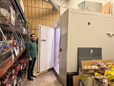 At Father Carr’s Place 2B, Jim Boehm showcases the Barr, Inc. walk-in freezer provided to support increased food storage needs as part of Coolers for a Cause.