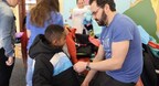 AIIR Consulting founder and CEO Dr. Jonathan Kirschner fits a student with a winter coat from Operation Warm during the Elevate Project's annual day of service.
