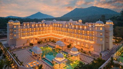 The striking exterior of Wyndham Grand Udaipur Fatehsagar Lake amid a backdrop of the Aravalli Mountains at sunset.