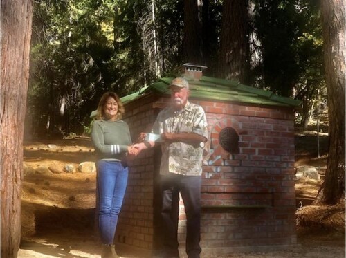 Sarah Fugate of GDHS receives a $6,000 donation from NSGW’s David Allen in Dutch Flat to support restoration of the Chinese Cemetery. A newly completed replica Burner stands in the background.