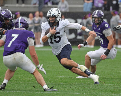 Yale dual-threat quarterback, Brogan McCaughey (#15) evades two opposing defenders.