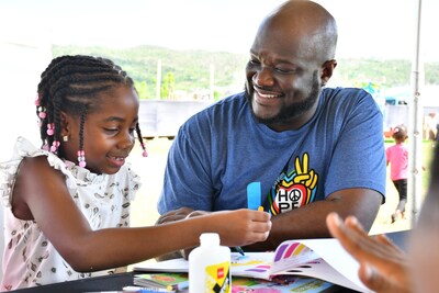 O’Brian Heron, General Manager of Sandals South Coast, connects with a young toy drive recipient during a special day focused on giving back to the Westmoreland community. O’Brian Heron, General Manager of Sandals South Coast, connects with a young toy drive recipient during a special day focused on giving back to the Westmoreland community.