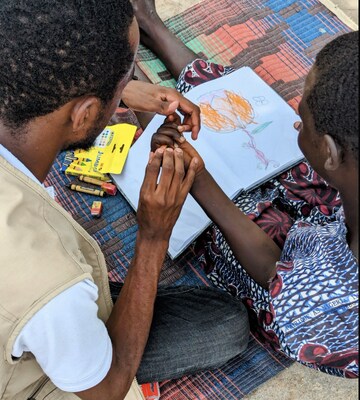 Santina, 13, draws a picture in the Rhino Refugee Settlement in Uganda. © HI