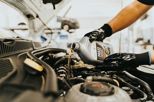 Man pouring oil into a car engine