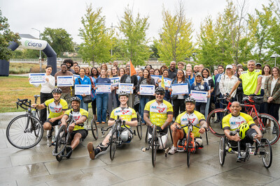 Employee volunteers from The Cigna Group celebrate Achilles International athletes after a 350-mile bike relay from Hartford, CT to Washington D.C., delivering mental health packs to youth while also honoring the nation's veterans ahead of September 11.