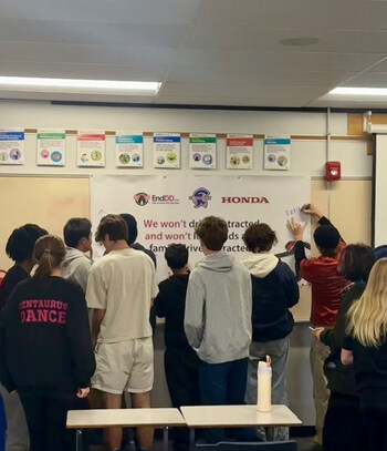 High School teens signing pledge to avoid distractions