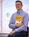 Artem Nikitin, marketing strategist and author of Marketing in 10 Days, holding the book.