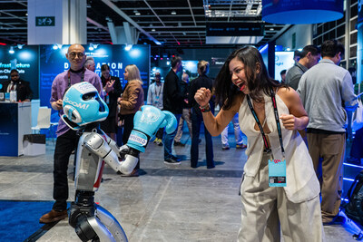 An attendee interacts with a robotics demonstration on the exhibition floor at Consensus Hong Kong 2026.