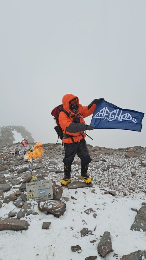Samuel Sidiqi raises the Afghan Peaks flag atop Mount Aconcagua (6,962m) on February 14, 2026.