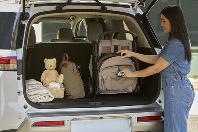 Parent places a compact, folded Britax Juniper+ stroller into the trunk of an SUV, showcasing space-saving design and convenient portability for everyday travel.