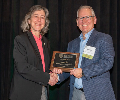 Hilary Sandler, outgoing WSSA president, presents Joseph Neal, Ph.D., with the Fellow Award, WSSA's highest honor, at the Society's recent annual meeting. Neal is a professor and extension specialist at North Carolina State University. Photo by Joe Omielan.