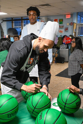 Derrick White signs basketballs for kids at the East Boston YMCA during Sun Life and Boston Celtics Fit to Win event.