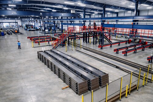 Stacked fabricated steel members inside Allied Steel Buildings’ McGregor, Texas facility, where integrated automation and material flow systems support high-volume structural steel production.