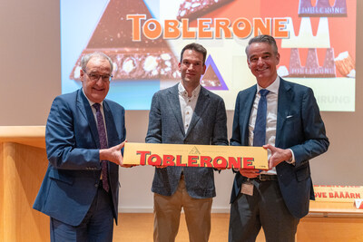 Handover of a 4.5-kilogram Toblerone to Swiss Federal President Guy Parmelin. From left to right: Guy Parmelin (Swiss Federal President), Thomas Kauffmann (Plant Manager, Toblerone Plant Bern Brünnen), and Volker Kuhn (Executive Vice President & President, Mondelez Europe).