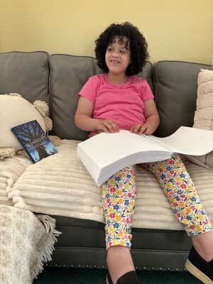 Rosie Williams reading her New Worlds Reading book in braille.