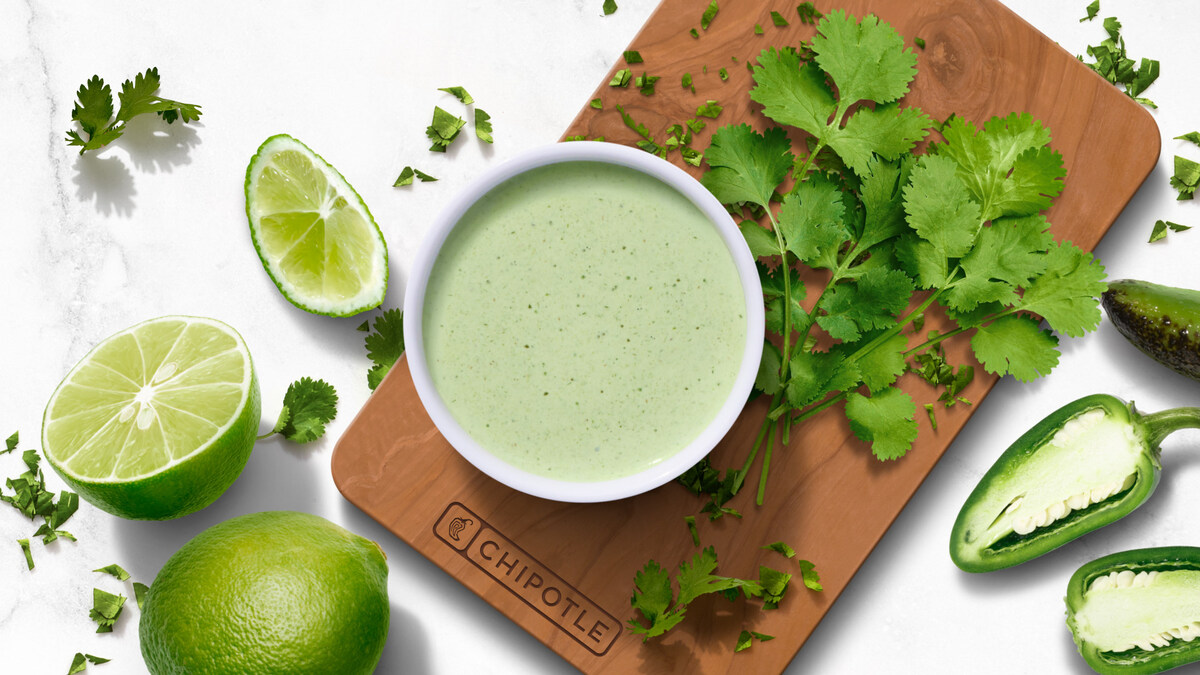 Chipotle Cilantro Lime Sauce surrounded by fresh limes, cilantro and jalapeños