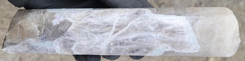 Figure 2: Pollucite with late stage spodumene/pollucite (white) veining displaying classic “tapioca” texture (white blebs) at a depth of ~43.7 m in drill hole CV25-979 from the Helios Zone. Core grades 0.5 m at 2.33% Cs2O within a wider mineralized interval of 4.9 m at 3.65% Cs2O (39.0 m to 43.9 m) (CNW Group/PMET Resources Inc.)
