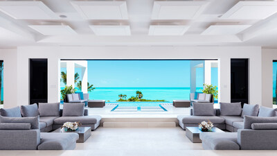 The residence’s main salon, situated at the center of the home just off the entry, opens seamlessly to the sparkling, turquoise waters of the Atlantic Ocean. The salon’s elegant design is representative of the modern, clean style that defines the property’s interiors, which span nearly 17,000 sf and include 15 total bedrooms and 15.5 baths. TritonLuxuryAuction.com.