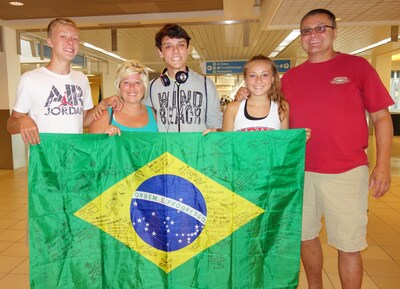 An Academic Year in America (AYA) host family in Ohio, welcoming their Brazilian exchange student to the United States at the airport.
