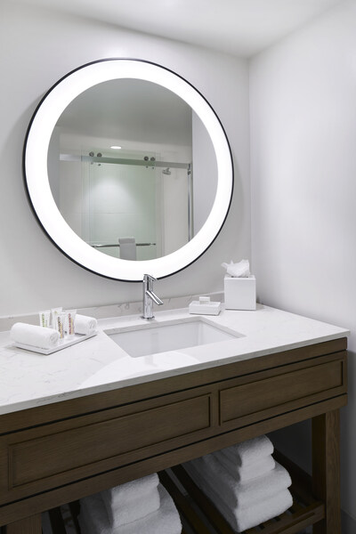 Clean, modern lavatories feature a glowing mirror and elegant finishes.