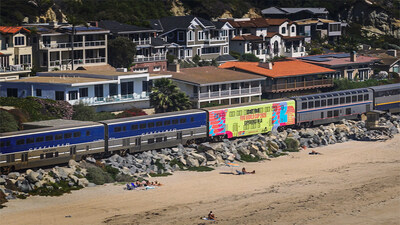 Un tren Amtrak Pacific Surfliner recorre la costa sur de California con un diseño especial de Los Ángeles Tourism que promociona los partidos de fútbol del verano de 2026 en Los Ángeles.