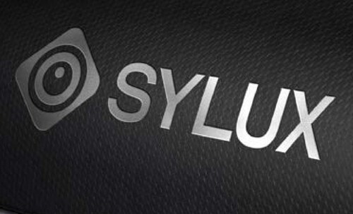 The SYLUX logo, representing Compal’s automotive infrared technology organization, is presented against a dark textured background, reflecting its professional and technological identity.