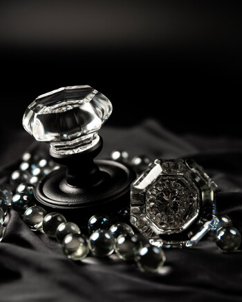 Faceted crystal knobs reflect light against matte black iron, highlighting the Ageless Iron™ collection’s signature contrast of brilliance and bold architectural form.