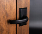 The Crescent lever in matte black iron brings a bold, sculptural curve to the door, creating a striking contrast against warm wood with its fluid, architectural form.
