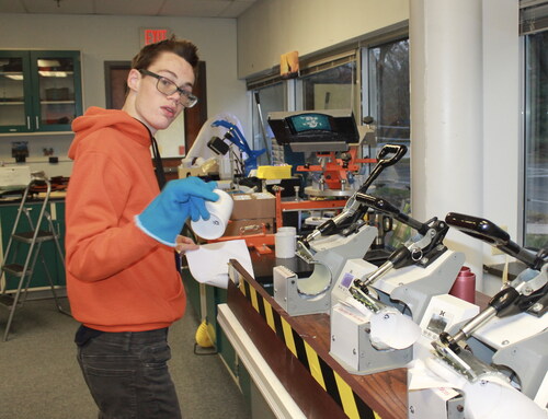 Ryan Fluharty working to design branded coffee mugs at his work training program. Photo credit: Parents With A Plan