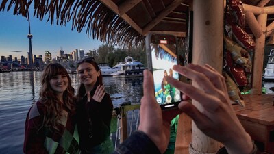 Guests enjoy skyline views and capture the moment while cruising Toronto Harbour aboard Palapa Tours’ tiki bar boat. (CNW Group/Palapa Tours Toronto)