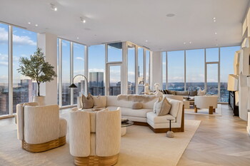 A light-filled living area with custom furnishings and floor-to-ceiling windows showcases sweeping, panoramic views across the Nashville skyline.