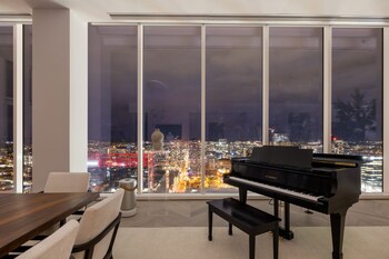 Panoramic nighttime views of downtown Nashville create a dramatic backdrop from the penthouse’s light-filled living and dining space.