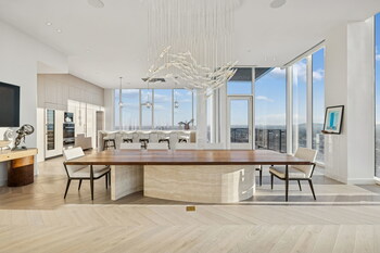 Designed for entertaining, the dining space flows seamlessly into the chef’s kitchen and bar area, all framed by panoramic city views.