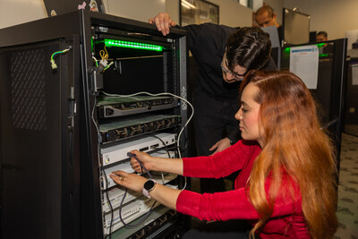 Students work on interconnecting a switch with a firewall in a Chaffey College cybersecurity class.