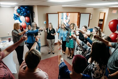 The team does a toast at the ribbon-cutting