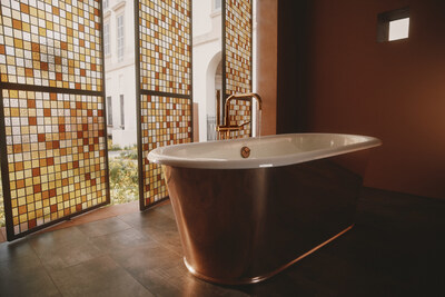The new Kohler Reverie enameled cast iron bath featuring a true metal copper shroud