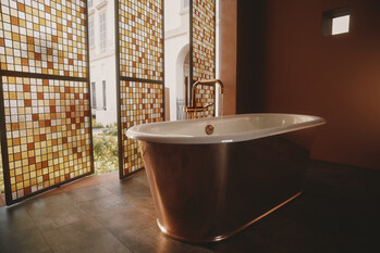 The new Kohler Reverie enameled cast iron bath featuring a true metal copper shroud