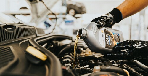 Mechanic pouring oil into an engine