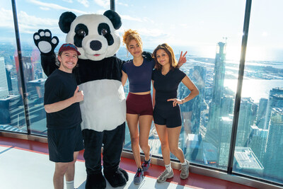 Harrison Browne, Ksenia Daniela Kharlamova and Anastasia  Kharlamova celebrate with the WWF panda at the top of the CN Tower. (c) WWF-Canada (CNW Group/World Wildlife Fund Canada)