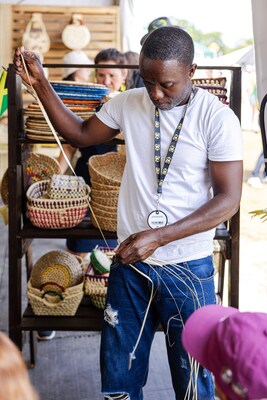 Omar Sheldon Daley, founder of FIRSTSTRAW Company, brings the spirit of Jamaica to life with a live weaving demonstration at the Sandals Resorts Cultural Exchange Pavilion, showcasing intricate, handwoven designs rooted in generations of tradition.