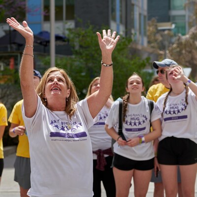 MBF Founder and President, Denise Bebenek looking up and waving to all of the children in the windows at SickKids during the annual HUG. (CNW Group/Meagan Bebenek Foundation)