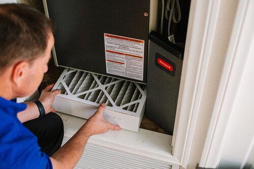 A Frank Gay Services technician inspects and replaces an air filter to help improve indoor air quality