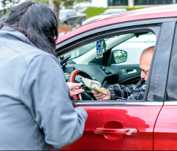 A volunteer from East Penn’s Retail Sales store hands cash to a guest for returning his batteries. All guests received double the standard reimbursement.