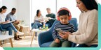 Mother showing child a video with music on headphones in a doctor's office