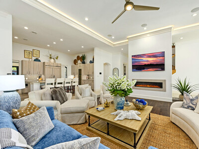 Residence interiors are bright and airy, with finishes such as hardwood and tile floors, archway accents and cove ceilings with custom lighting. Shown here are the main residence’s living room (foreground) and kitchen (background; middle & left). The property has 3 living structures: a main residence, guesthouse and studio. TexasLuxuryAuction.com.
