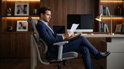 A professional working from home, fully supported by the advanced dynamic lumbar system of the upcoming Sunaofe Atlas ergonomic chair.